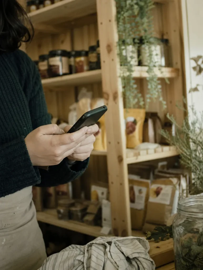 Manos con el celular en una tienda mientras entran mensajes de clientes